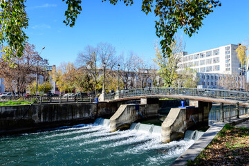 Old green metallic rusted bridge over Dambovita river in Bucharest, Romania, in a sunny autumn day
