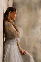 a girl in a dress against a shabby wall