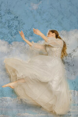 a girl in a dress jumping against a shabby wall