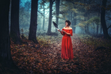 Shaman woman in deep mystical misty forest, with feathers fan with deer antler in hand. Feathers...