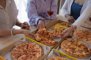 Close up hands get slice of pizza, Group of young asian office girl friends having fun and celebrating pizza on table during party