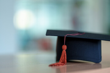 Black Graduation Hat placed on wood background