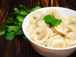 dumplings with meat in a white bowl with a bunch of cilantro