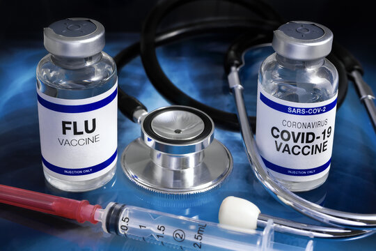 Bottles of vaccines for Influenza and Covid-19 Virus for vaccination. Flu and Sars-cov-2 Coronavirus vaccine vials in the medical clinic over Radiography pulmonar