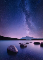 Two Jack lake. Sunbeams in a valley. The Milky Way over the lake. Natural landscape with bright...