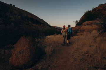 Frau wandert zusammen mit Tochter bei Sonnenuntergang durch das Erongo Gebirge, Namibia
