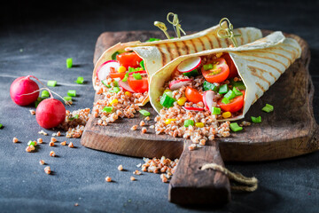 Tasty and healthy vegetarian tortilla with groats and fresh vegetables.
