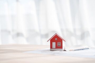 Red color House toy model with Solar Powered, engineering architect blueprint, Solar and Green Energy concept.