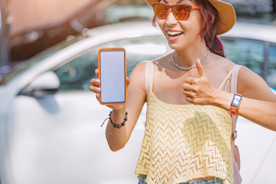 Girl using smartphone application to rent a carsharing car or call a taxi