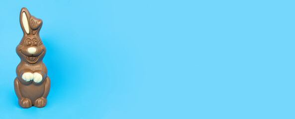 Easter. Chocolate bunny on a blue background. Banner. Holiday concept, gifts, customs, copy space, text, template, poster, business,congratulations, invitation,action,chocolate,sweets, confectionery.