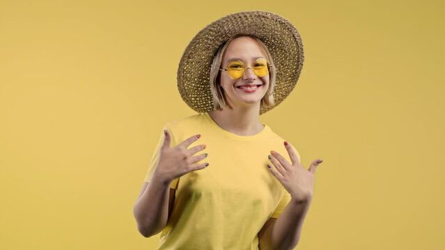 Lady asks join her, beckons with inviting hand hugs gesture. Young woman calling - Hey you, come here. Hipster teenager, playful, inviting to come. Yellow studio background