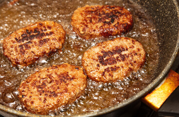 Cutlets are fried in oil in a frying pan.