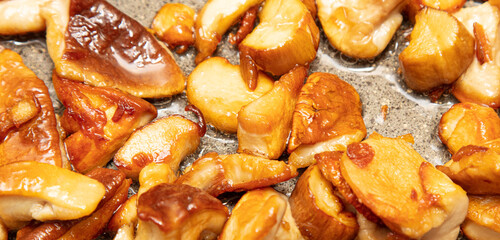 Fried mushrooms in oil in a frying pan.