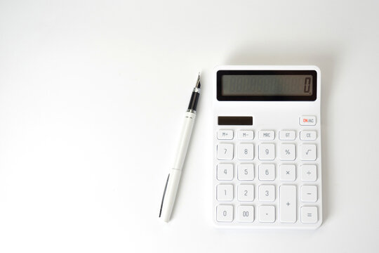 Calculator and Pen on Isolated White Background