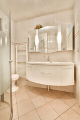 Glass partition between shower tap and wall hung toilet in modern restroom at home