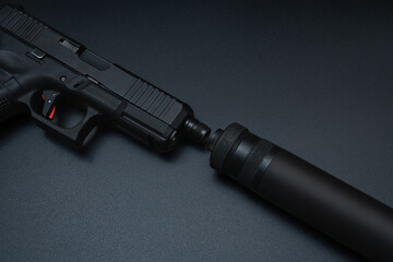 Attaching a silencer to a pistol, close up photo.