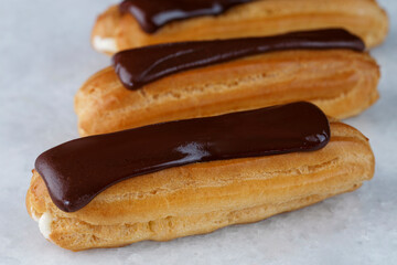 Eclair with chocolate cream, mint, strawberry on white background