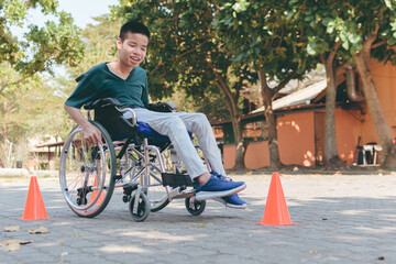 Young man with disability training move wheelchair by himself in the ramp of home or hospital,school,nursery, Self-help development in daily life, Positive photography and Good health concept.