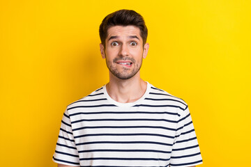 Photo of young funny grimace guy student oops mistake bite lips nervous forgot his house keys lost isolated on bright yellow color background