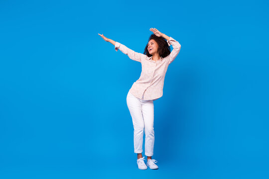 Full length photo of shiny positive lady wear pink shirt smiling dancing isolated blue color background