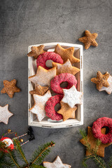 christmas ginger cookies with red rings from chocolate in white wooden box on grey background 