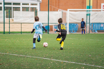 Young soccer player running towards goal. Children playing soccer match