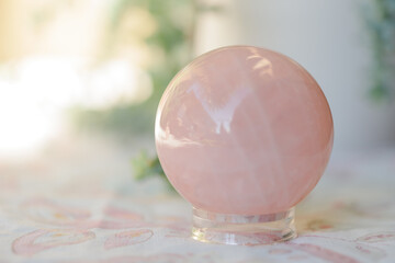 Esfera de cuarzo rosa sobre fondo claro.