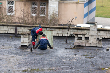Workers are repairing the roof of a multi-story building.