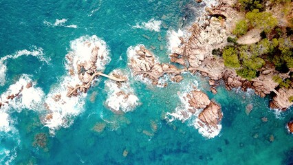 aerial view of Pont Cala Canyet at Costa Brava with rocks in the cyan Mediterranean Sea, coastline between Sant Feliu de Guíxols and Tossa de Mar, Canyet de Mar, Girona, Spain