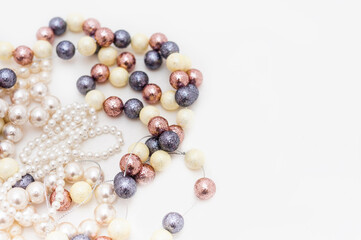 Pearl beads with beads of different sizes and colors are collected in a circle. Top view. Copy space