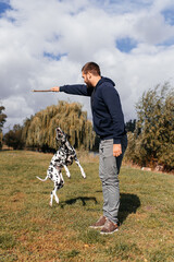 handsome young man with dog outdoors. a man on green grass with a dog. cynologist