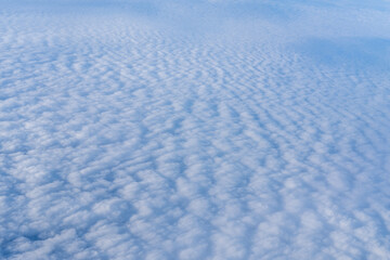 Background of a pink white heavenly sky with fluffy dense clouds, top view from an airplane. Sky Gradient