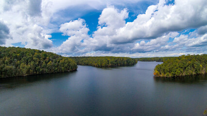 Fototapeta premium Aerial view of an elongated lake with winding coast and blue sky and clouds in Maryland