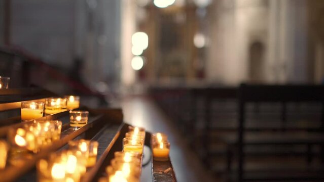 Candles, prayer candles burning in a row inside a Catholic church for praying and spirituality,
