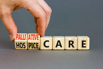 Palliative or hospice care symbol. Concept word Palliative care Hospice care on wooden cubes. Doctor hand. Beautiful grey table grey background. Medical palliative or hospice care concept. Copy space.