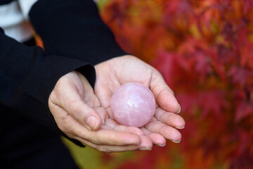 Esfera de cuarzo rosa sobre manos de chica