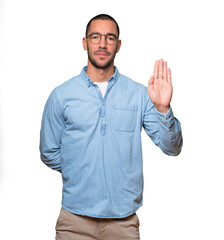 Happy young man making a gesture of stop with his palm