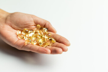 Vitamin D3 capsules on the hands. White background, space for text.
