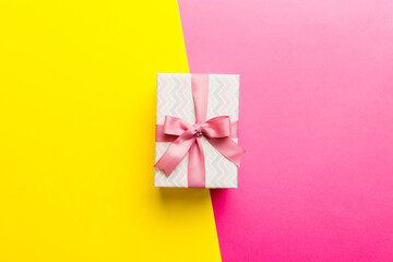 holiday paper present tied pink ribbon bow top view with copy space. Flat lay holiday background. Birthday or christmas present. Christmas gift box concept with copy space