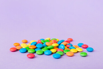 Pile of delicious colorful sweet candies on colored background top view. Confectionery decor