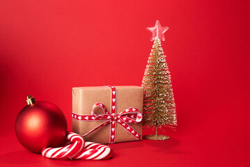 decorative Christmas trees and gift boxes on red background against red background