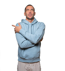Concerned young man making a gesture of being cold