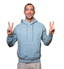 Happy young man making a victory gesture with his fingers