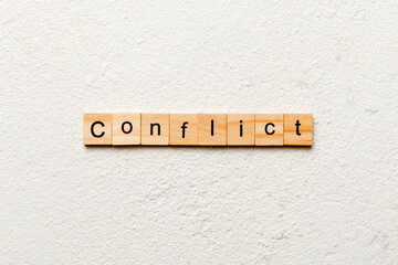 CONFLICT word written on wood block. CONFLICT text on cement table for your desing, concept