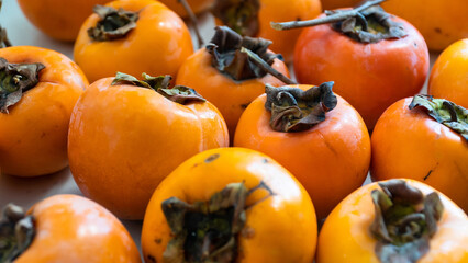 Persimmon fruit. Group of fresh organic ripe persimmon fruits high angle view. Cennet hurmasi or trabzon hurmasi in Turkish. Selective focus included.