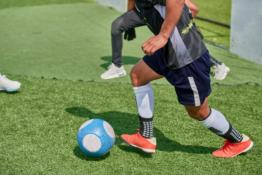 Latino Youth Playing Soccer On Synthetic Field