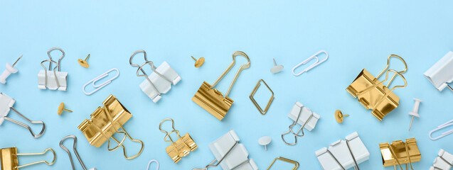 Obraz premium Binder clips on light blue background, flat lay. Banner design
