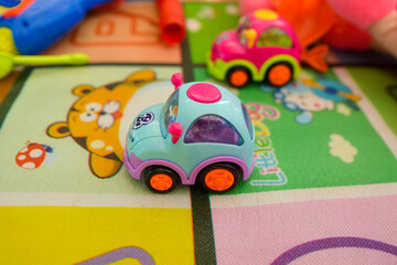 small car toy.toy car from front view with cheildren carpet. toy cars on the table .Children's playroom with plastic colorful educational blocks toys. Games floor for preschoolers kindergarten

