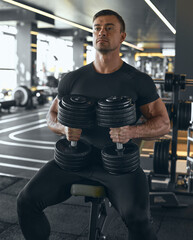 Muscular Confident Athlete or Bodybuilder arms workout with heavy weights dumbbells. Camera focus on dumbbells