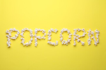 Word Popcorn made of tasty ingredients on yellow background, top view